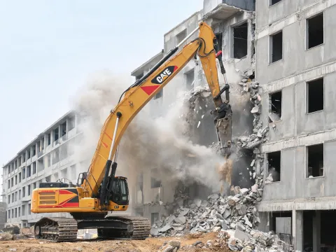 High-reach excavator on building demolition site